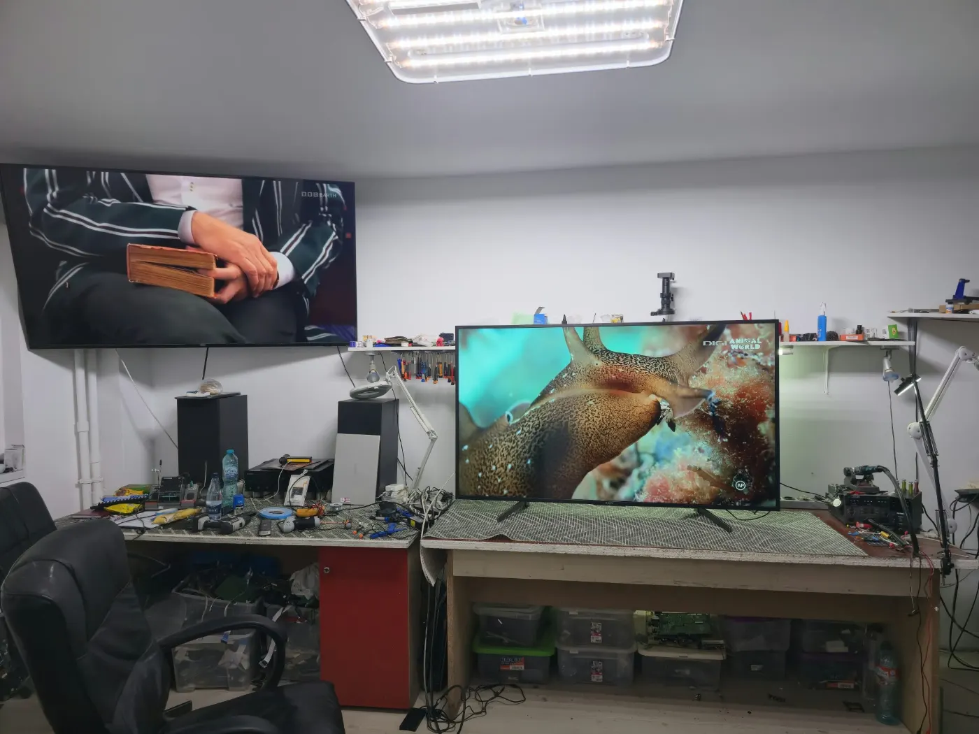 Atelierul de reparații TV din Militari, București, cu bancuri de lucru și televizoare în test