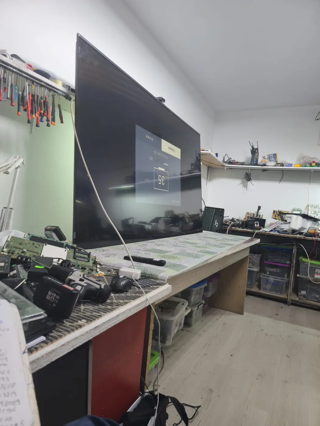 Televizor TCL 85C755 de 85 de inch pe bancul de lucru din atelierul din Militari, în timpul testului